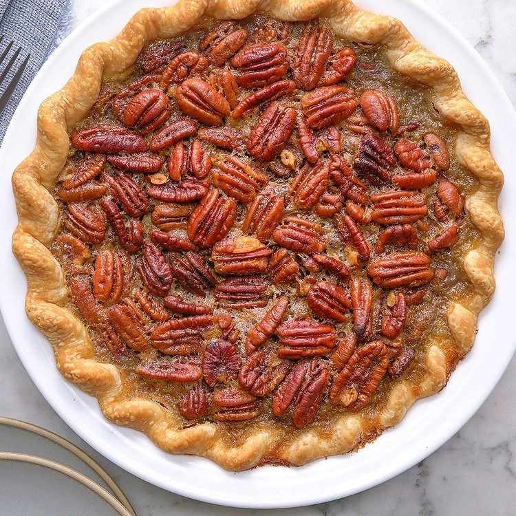 Slice of Vermont maple pecan pie with golden caramel filling and crisp toasted pecans