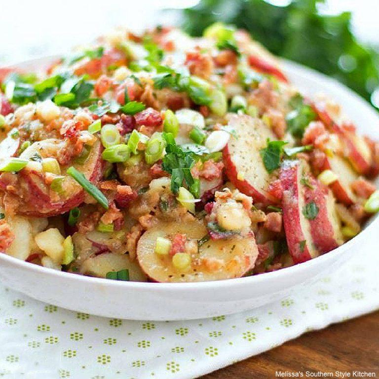 Warm German potato salad with tender potatoes, tangy vinegar dressing, crispy bacon, and fresh herbs