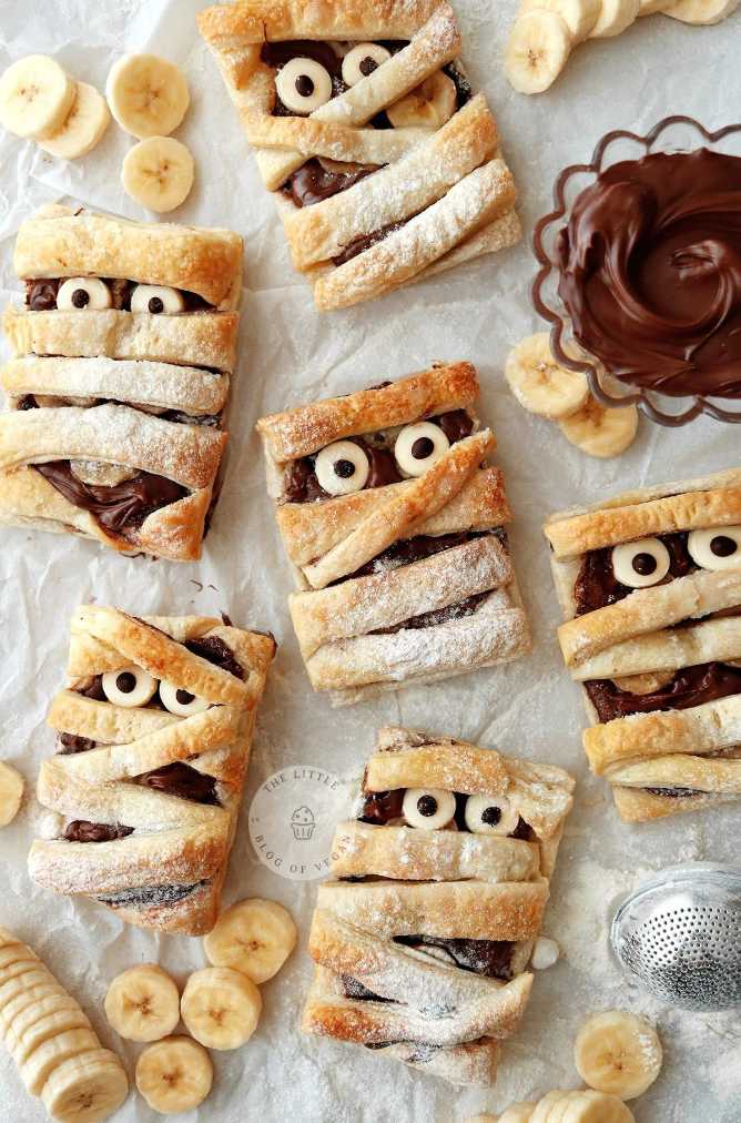 Banana halves wrapped in flaky puff pastry with Nutella “bandages” and chocolate chip eyes.