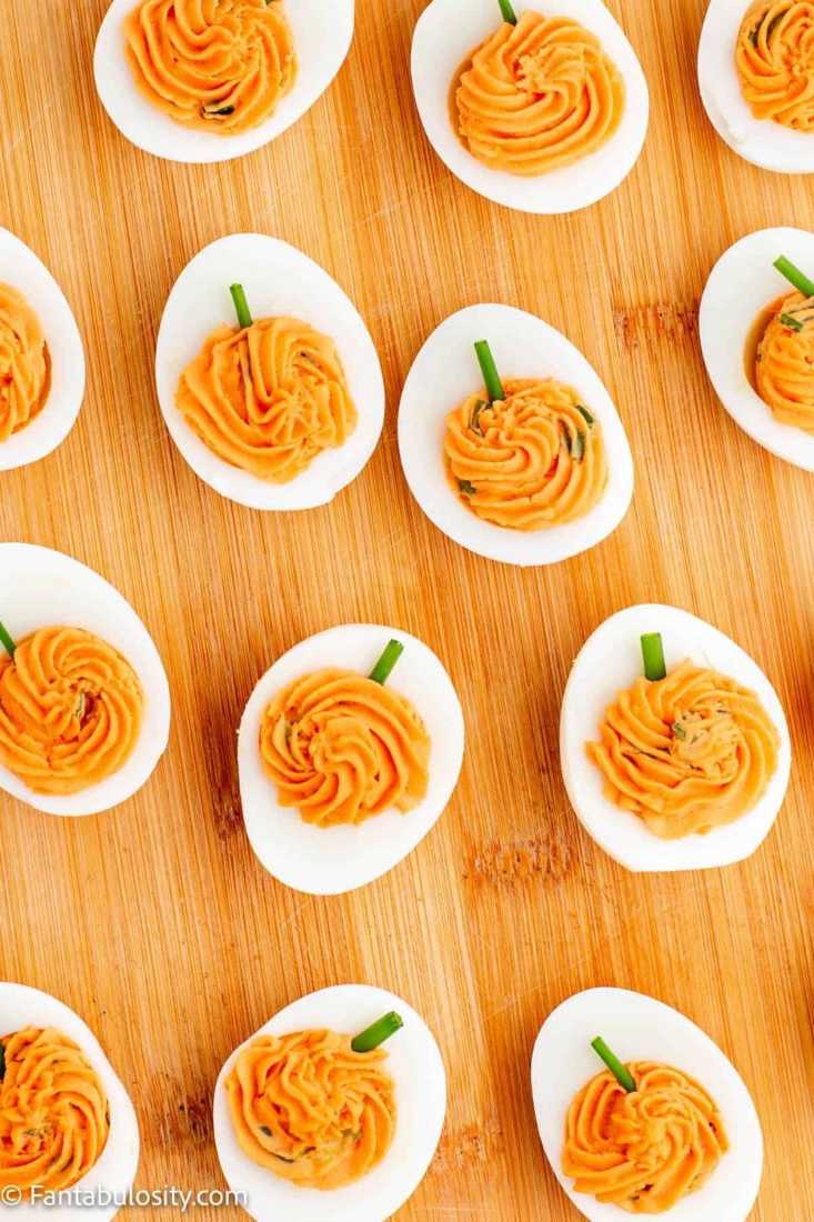 Deviled eggs shaped like pumpkins with chive stems.