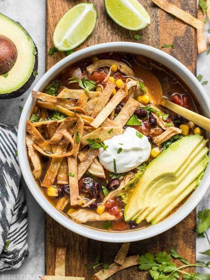 Slow‑cooked chicken tortilla soup, tangy lime, rich tomato broth, shredded chicken, crunchy tortilla strips