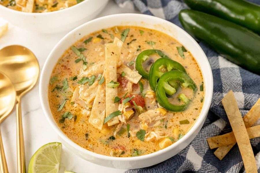 Classic chicken tortilla soup with hearty tomato broth, shredded chicken, crispy tortilla strips, avocado, and lime