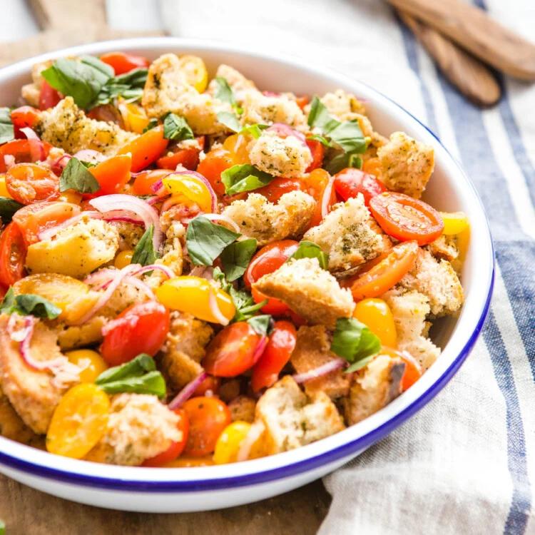 Classic summer panzanella featuring crusty bread cubes, ripe tomatoes, basil, mozzarella, olive oil