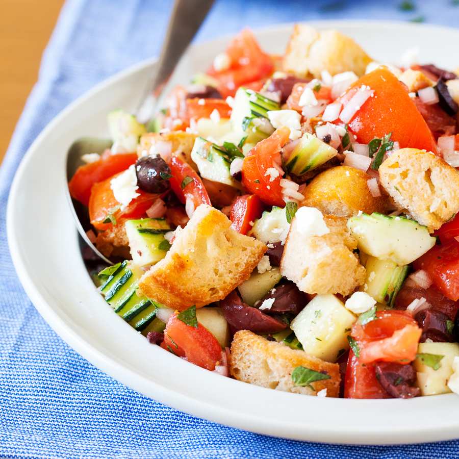 Classic summer panzanella with crusty bread cubes, ripe tomatoes, basil, mozzarella, olive oil
