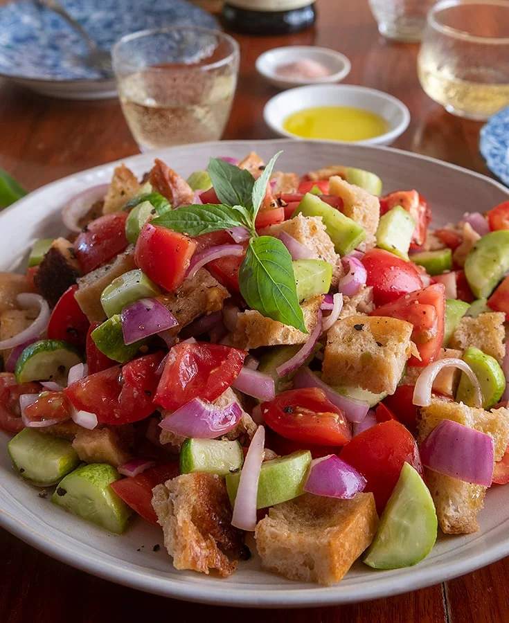 Classic Tuscan panzanella with crusty bread cubes, ripe tomatoes, basil, mozzarella, olive oil