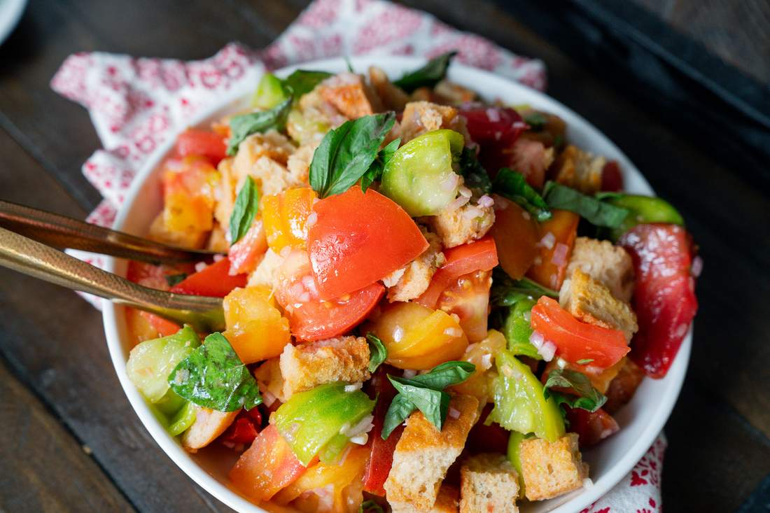Classic Tuscan panzanella with crusty bread cubes, ripe tomatoes, basil, mozzarella, olive oil