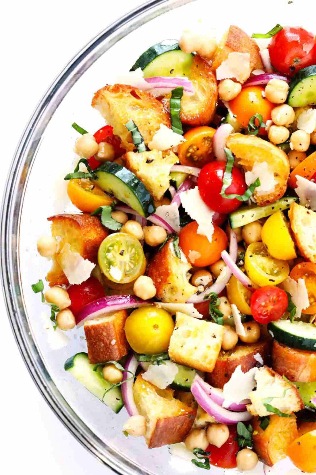 Classic summer panzanella salad with crusty bread cubes, ripe tomatoes, basil, mozzarella, olive oil