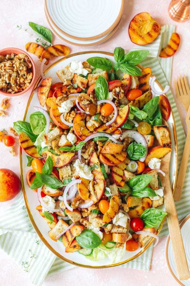 Peach & mozzarella panzanella with crusty bread cubes, ripe tomatoes, basil, and creamy mozzarella in a sunny vinaigrette