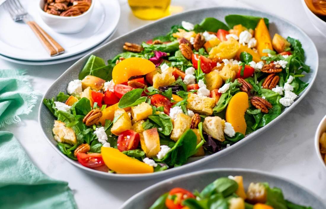 Peach & mozzarella panzanella featuring crunchy Tuscan bread, juicy tomatoes, basil, and creamy mozzarella in a zesty vinaigrette