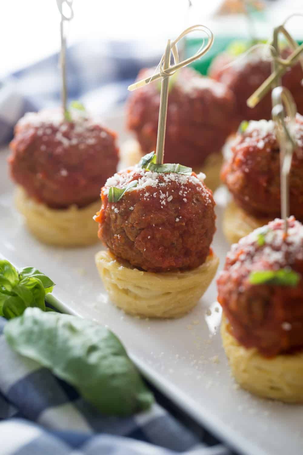 Bite‑size meatball nests of spaghetti, topped with marinara and parmesan
