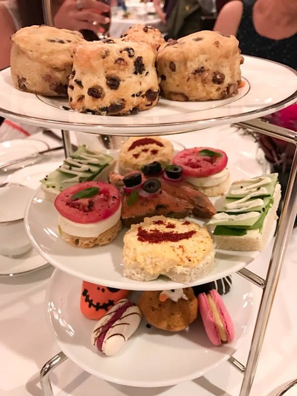 Three-tier stand with savory bites, pastries, and desserts arranged neatly